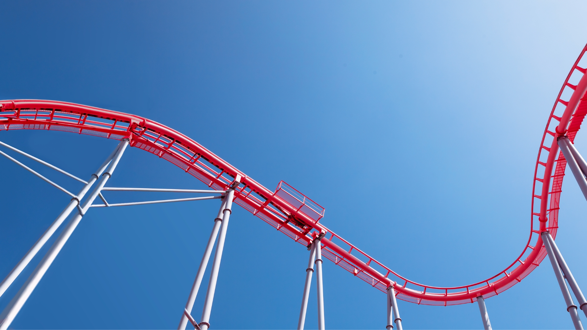 Red Roller coaster tracks against a blue sky